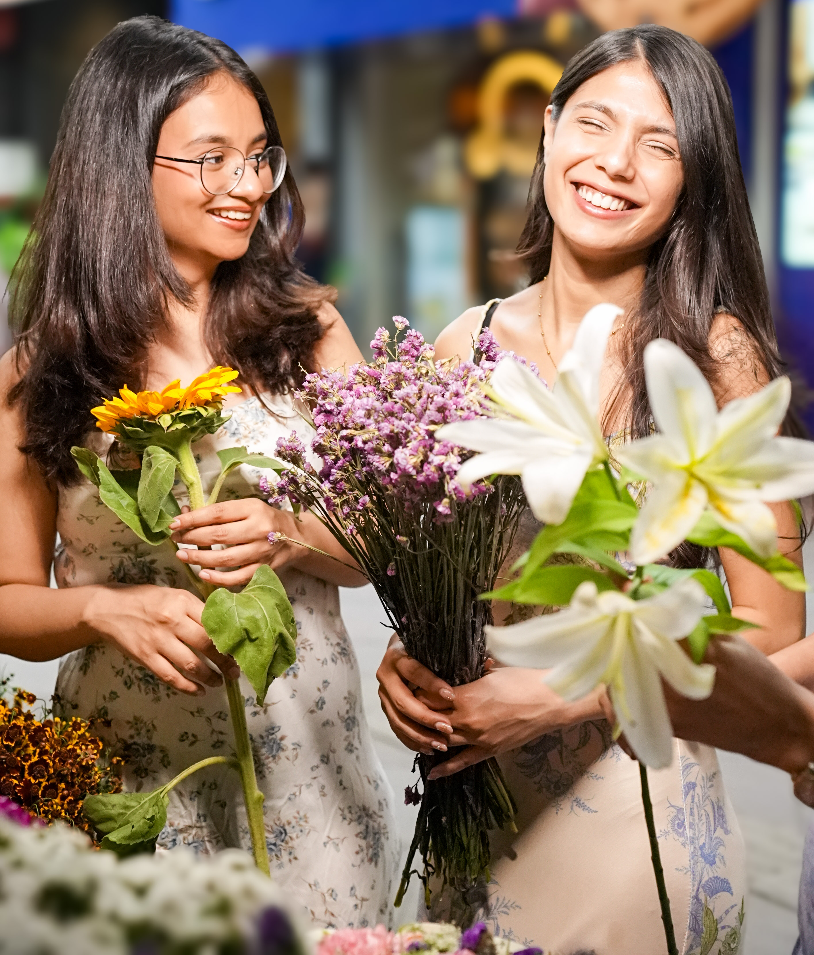 A photograph of two smiling young women holding fresh flowers, representing the idea of preserving fertility and having the freedom to choose when to start a family.
